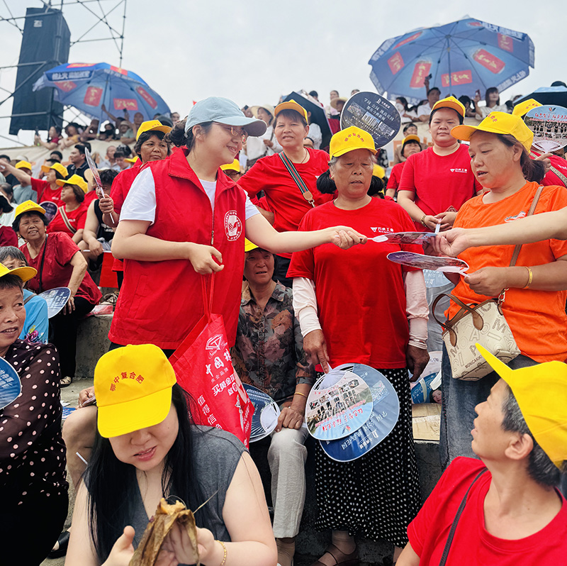 志愿者在大江口龙舟比赛现场为观赛者发放凉扇、粽子.jpg